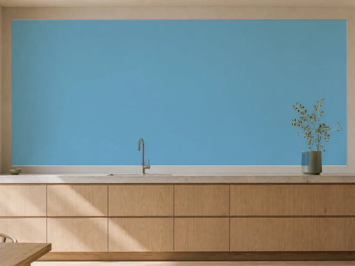 Küchenrückwand „RAL 5024 Pastellblau Weite“ als installierte Rückwand in einer warmen Küche