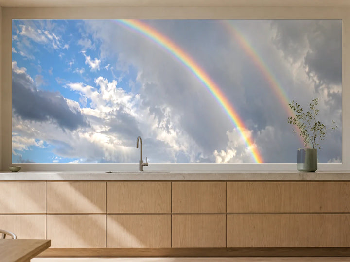 Küchenrückwand „Doppelter Regenbogen über Wolken“ als installierte Rückwand in einer warmen Küche