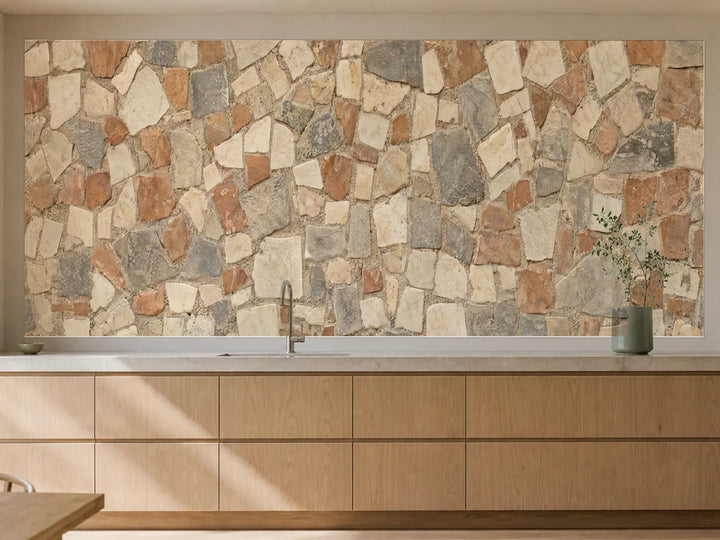Küchenrückwand „Kleine Steinmosaike in Creme und Rauch“ als installierte Rückwand in einer warmen Küche