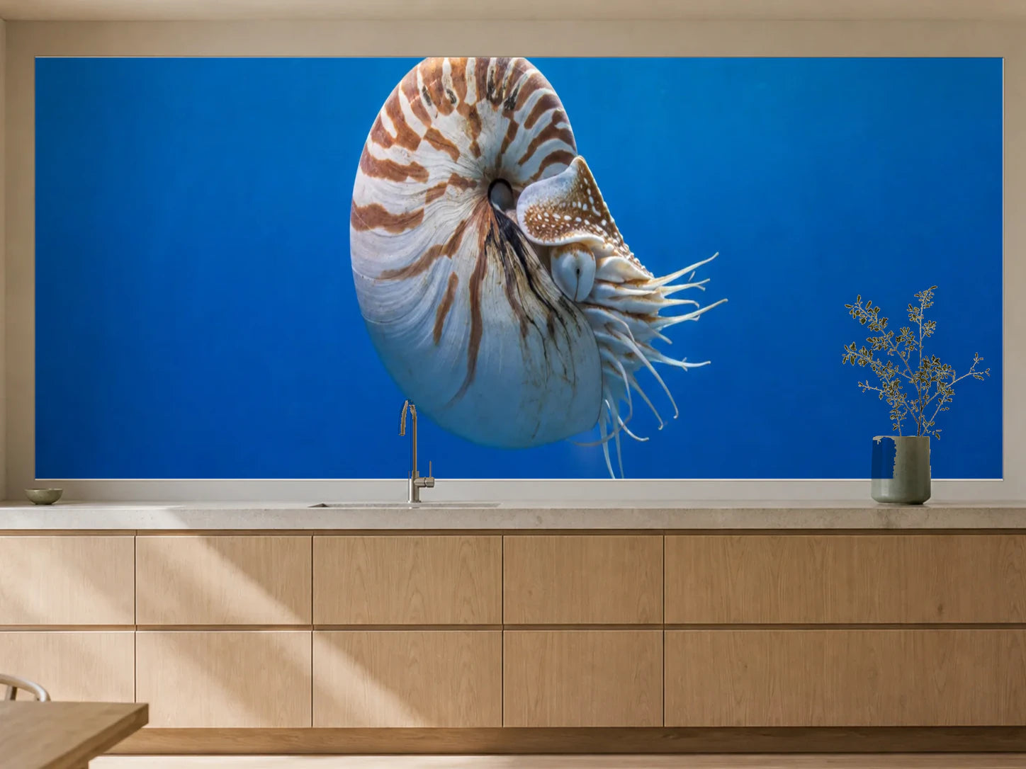 Küchenrückwand „Nautilus in blauer Tiefe“ als installierte Rückwand in einer warmen Küche