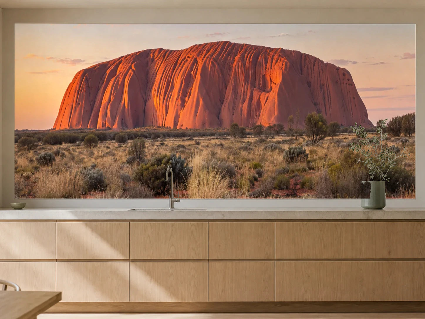 Küchenrückwand „Uluru im ersten Sonnenlicht“ als installierte Rückwand in einer warmen Küche