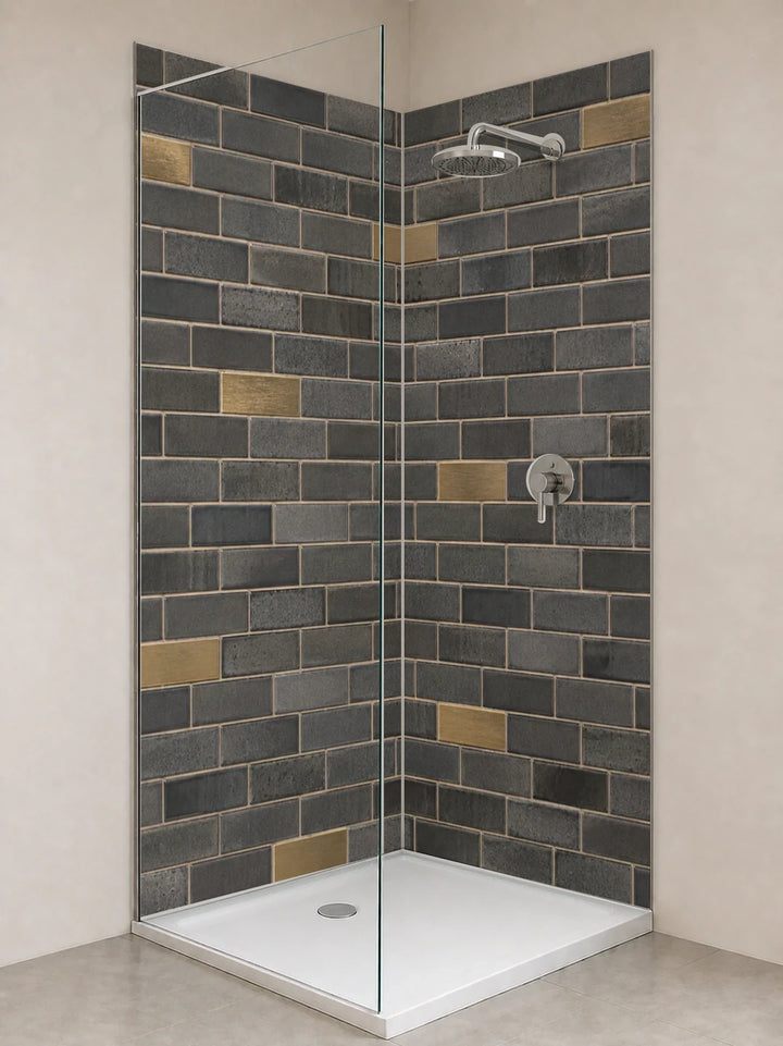 Duschrückwand „Graphitmosaik mit Messingakzenten“ als installierte Rückwand in einer hellen Dusche
