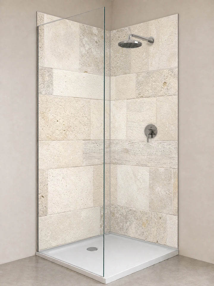 Duschrückwand „Kalkstein in Morgenweiß“ als installierte Rückwand in einer hellen Dusche