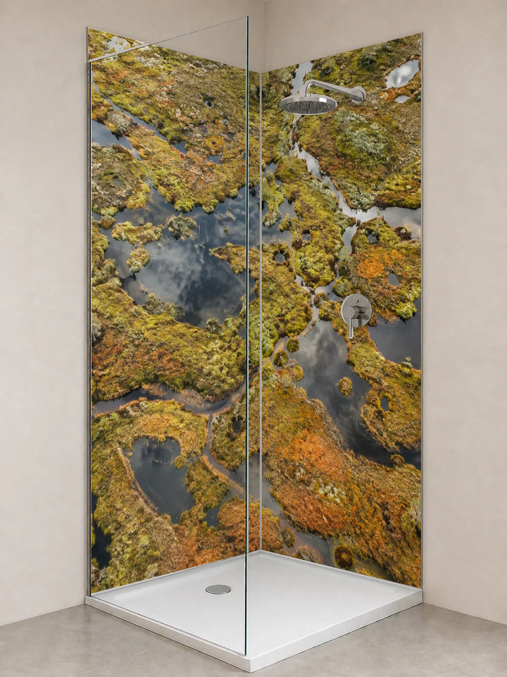 Duschrückwand „Moorlandschaft mit dunklen Wasseraugen“ als installierte Rückwand in einer hellen Dusche