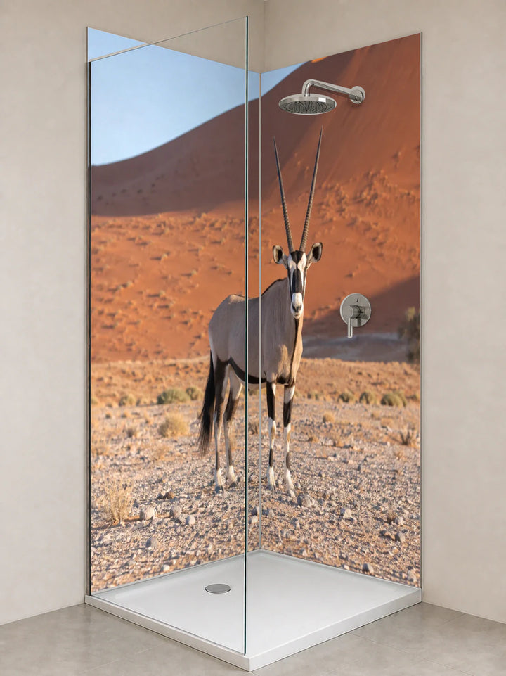 Duschrückwand „Oryx vor roten Namibdünen“ als installierte Rückwand in einer hellen Dusche
