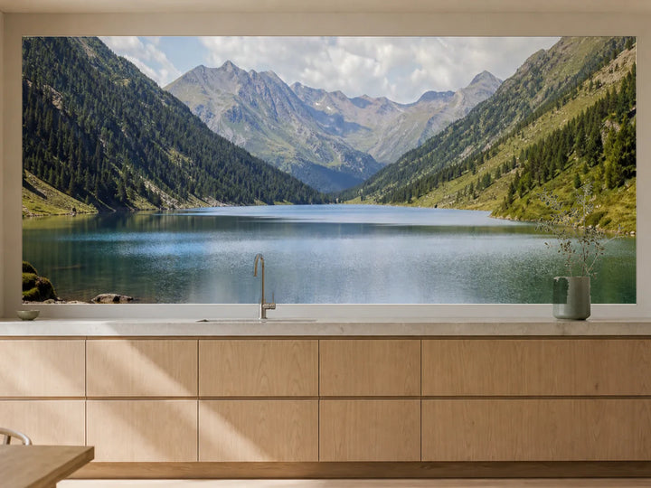 Küchenrückwand „Alpensee in Fernblau“ als installierte Rückwand in einer warmen Küche